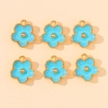 Detailed view of six light blue enamel cherry blossom charms with gold-plated edges and loops - Blue