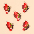 Detail van vijf rood-zwarte vlinderhangers met groene strepen voor DIY-sieraden maken - Rood
