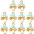 Close-up of 10 mint green enamel mushroom pendants with gold metal edges for DIY jewelry - Lake Blue