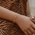 Elegante bracciale di perle d'acqua dolce placcato oro su polso con sfondo zebrato - Stile Perla Onda Minimalista (KB0196)
