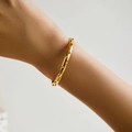 Bracelet jonc doré poli avec petits détails perlés porté au poignet d'une femme - Style de Décoration de Perles (KB0470)
