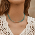 Collier en perles turquoise fait main avec détails dorés porté par un mannequin - Petites Perles Bleu Ciel Perles Dorées Devant (KN0056)