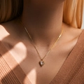 Golden heart pendant necklace with large clear zircon stone worn by a model - 18K Gold / Wrapped Heart Style (KN0322)