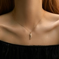 Close-up of a 18K gold-plated feather pendant necklace with shimmering cubic zirconia - Angel Wings Style (KN0255)