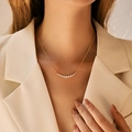 Elegante collana placcata in oro con zirconi curvi indossata da una modella - Stile Arco Sfumato (KN0276)