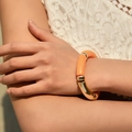 Close-up of bohemian orange resin and gold metal curved tube beaded stretch bracelet - Glossy Thick Tube Style (AB0009-12) / Bright Orange