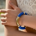 Close-up of blue and gold elastic tube bead bracelet worn on wrist with white lace - High Gloss Lacquer Style (AB0009-21) / Bright Blue