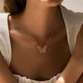 Elegante collana a farfalla dorata con ciondolo in zirconi indossata da una modella - Stile a Sfumatura di Farfalla Cava (KN0272)