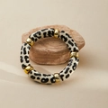 Macro shot of chunky leopard print acrylic bracelet on a stone with gold spacers - Black White Leopard (AB0008-26)