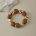 Gros plan de perles marbrées brunes et d'accents dorés irréguliers sur un bracelet rétro - Marbre Brun (AB0050-5)