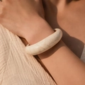 Close-up van crème beige hars armband met marmeren textuur om de pols - Afgeronde Brede Drijfzandpatroon Stijl (AB0027-8)