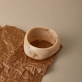 Detailopname van een dikke crème marmeren hars armband met bruine textuurpatronen - Crèmewit Marmer Brede Stijl (AB0056-1)