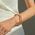 Détail d'un bracelet en résine translucide avec ombres élégantes sur le poignet du modèle - Rose Nude (AB0026-7)