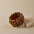 Macro detail of wide amber resin elastic bracelet leaning against a natural stone - Amber Brown (AB0063-6)