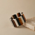 Détail d'un large bracelet élastique avec segments en résine noire et ambre sur pierre - Épissage Tricolore Vintage
