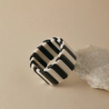 Détail macro d'un large bracelet élastique aux modules en résine rayés noir et blanc - Patchwork Noir et Blanc