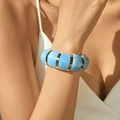 Bracelet bohème en résine marbrée bleue avec anneaux dorés porté par un mannequin - Texture Nuage Bleu Ciel (AB0012-11)