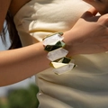 Close-up of chunky gold-tone and marble acrylic stretch bracelet on woman's wrist - Gold White Polyhedron Beaded Style (AB0038-1)