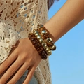 Primo piano di bracciali elastici bohémien a strati con motivo tartarugato e finitura oro - Stile Occhio di Tigre Caffè Scuro (AB0066-4) / Set di 3 pezzi