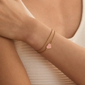 Double-layered gold bracelet with pink heart pendant and star charms on model wrist - Stainless Steel / Pink Star Heart Double Layer (SB0009-1)