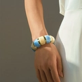 Détail du bracelet en acrylique marbré bleu et crème avec accents dorés sur le poignet - Épissure Bleu & Blanc (AB0012-16)