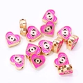 Gros plan de perles en forme de cœur œil de protection en émail rose pour bijoux - Rose rouge