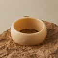 Minimalist wide creamy resin bangle bracelet with a smooth polished finish shown on paper - Creamy Minimalist Bangle (AB0042-6)