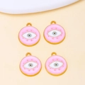 Macro shot of four light pink enamel evil eye pendants with gold alloy base and top rings - Pink