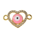 Macro-opname van gouden hartvormige evil eye hanger met roze emaille en kristallen - Roze