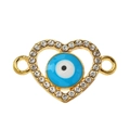 Macro detail van de vergulde hart hanger met strass steentjes en evil eye kraal - Blauw