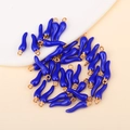 Macro shot of dark blue glazed chili pendants with gold metal rings for DIY jewelry - Sapphire Blue