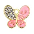 Makro-Detail des rosa Emaille-Schmetterling-Anhängers mit glänzenden Strasssteinen und Gold - Rosa