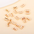Détail de la perle lettre E en émail blanc doré avec trous latéraux pour bijoux DIY - E (px0918)
