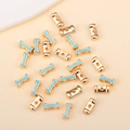 Vue macro de perles alphabet plaquées or avec émail bleu clair pour bijoux DIY - I (px0918)