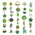 Detailansicht von 30 grünen Emaille-Anhängern mit Blumen, Tieren und Herzmotiven im Set - Grüner Stil