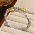 Pulsera de cable industrial en acero de titanio con extremos dorados en joyero - Dorado y Plateado