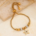Bracciale stella dorata con cristalli e catena regolabile su sfondo effetto marmo - Oro Stella A Cinque Punte