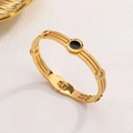 Rose gold Roman numeral bangle featuring a black center and twisted triple-strand band - Gold