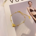 Minimalist gold titanium heart bracelet with small beads and lobster clasp on magazine - Gold