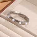 Pulsera elástica de metal plateado con perlas blancas en bandeja de terciopelo beige - Estilo con Decoración de Perla Redonda / Plateado