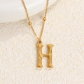 Collar de acero de titanio dorado con un colgante letra H y textura de bambú detallada - Oro H