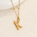 Collar de acero de titanio dorado con colgante de letra K de textura rugosa elegante - Oro K