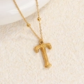 Collar de acero de titanio con colgante de letra T dorada y textura martillada única - Oro T