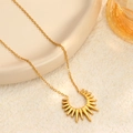 Elegante collar dorado con colgante de rayo de sol en una bandeja de cerámica - Girasol