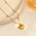 Elegante collar con colgante de manzana dorada y cadena de cuentas en plato decor - Manzana