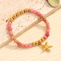 Bracelet étoile de mer en pierres naturelles roses et perles dorées sur support en pierre - Style Étoile de Mer (07)