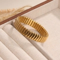 Pulsera elástica de acero inoxidable dorado pulido en una bandeja de joyería beige - Estilo de Superficie Arqueada de 12mm / Dorado