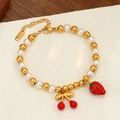 Pulsera de acero inoxidable dorado con perlas y dijes de cereza y fresa brillantes - Pulsera de Perlas Doradas