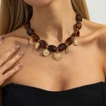 Λεπτομέρεια boho κολιέ Y με χάντρες μάτι της τίγρης και χρυσά μενταγιόν ήλιου - Στυλ Μενταγιόν Ήλιος με Κεχριμπαρένιες Χάντρες