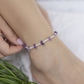 Cavigliera bohémien con perle di pietra viola naturale e ciondoli bianchi sul piede - Stile di Perline a Mano in Pietra Viola (0718)